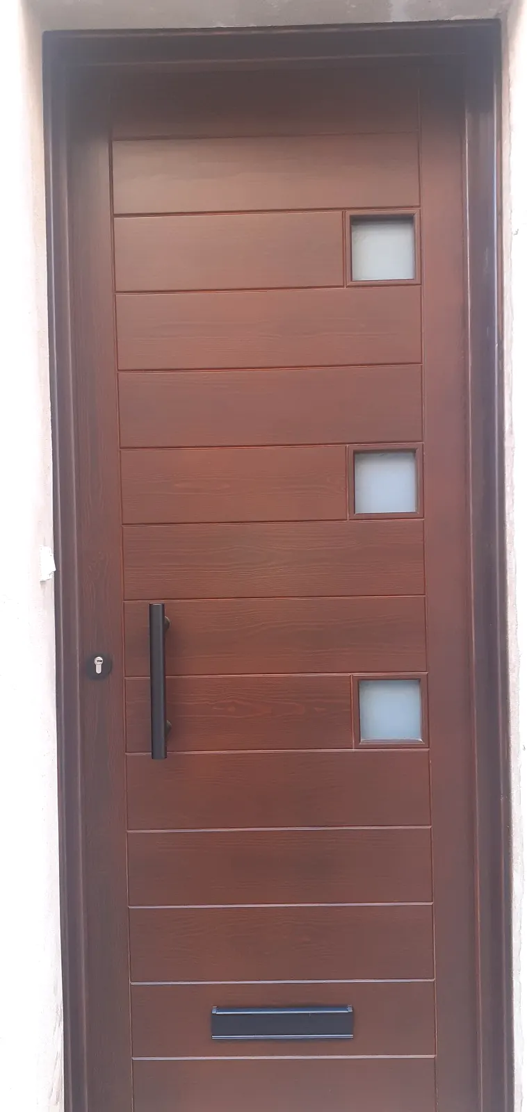 Porta d'entrada de fusta moderna amb finestretes quadrades fabricada a Les Borges Blanques