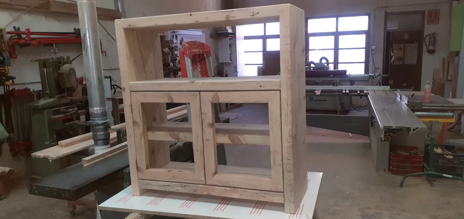Moble de fusta de pi amb portes de vidre en procés al taller de Fusteria Viladegut